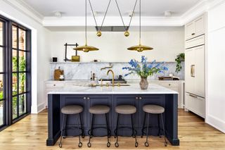 A kitchen with pendant lights above the island