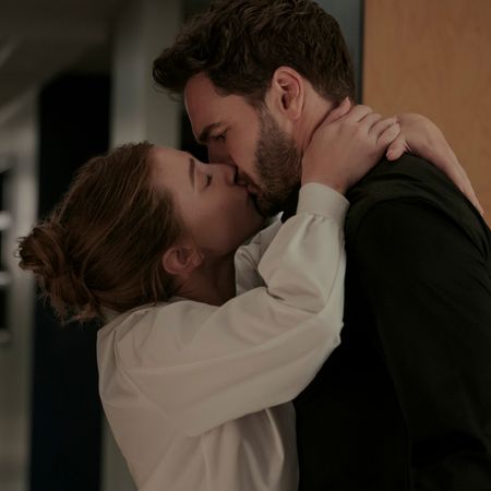 lili reinhart as olive and tom bateman as adam kissing in a hall in the movie the love hypothesis