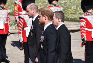 Prince William, Duke of Cambridge; Prince Harry, Duke of Sussex and Peter Phillips walk behind Prince Philip, Duke of Edinburgh's coffin, carried by a Land rover hearse, in a procession during the funeral of Prince Philip, Duke of Edinburgh
