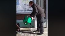 Rail staff pour dirty water onto a homeless man