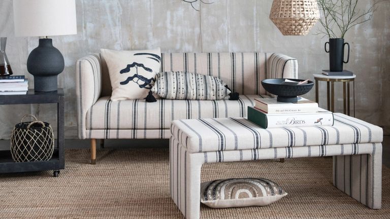A striped couch and upholstered bench seat in a Scandi-style living room