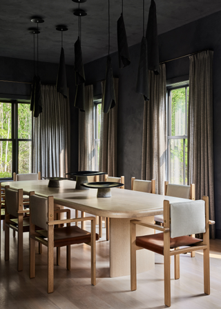 A moody dining room with wooden furnishings and dark decorative accents