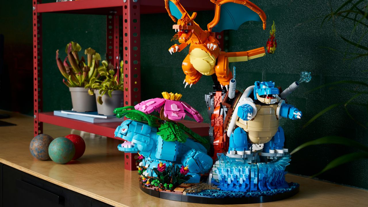 The Lego Venusaur, Charizard, and Blastoise set on a sideboard, almongside a red shelving unit and plants