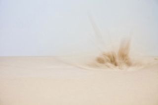 An explosion in the sand in a desert.