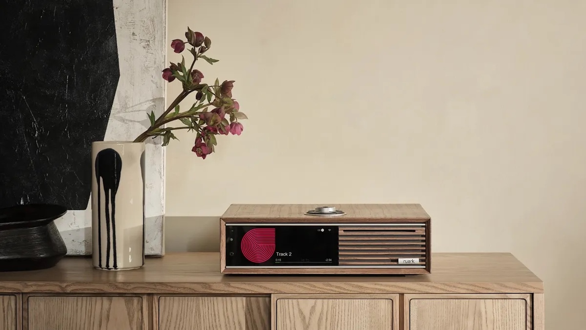 Ruark Audio R710 Music Console All-In-One System sat on a side table with a plant next to it 