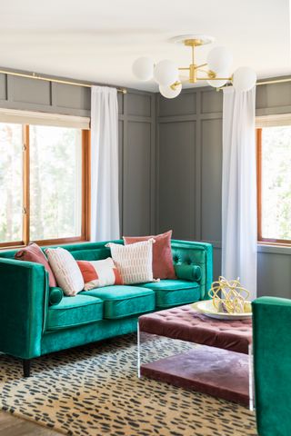 A living room with light gray walls, and turquoise sofas