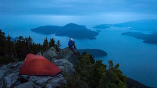 Hiker camping on rocks at night