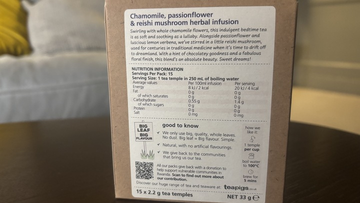 The back of a Reishi mushroom tea box on a coffee table.