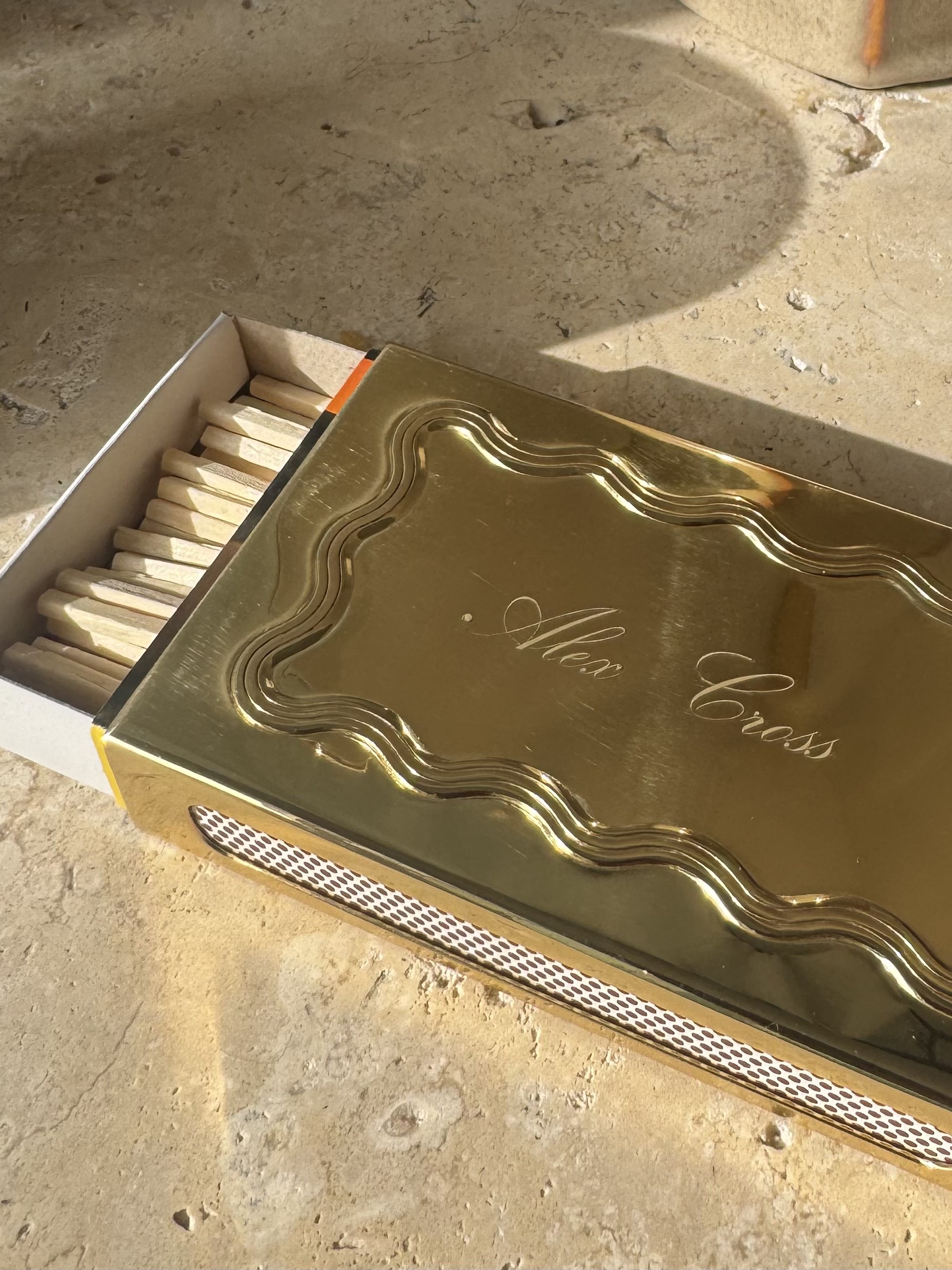 A metal monogrammed matchbox.