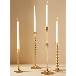 four gold candlesticks in different twisted styles