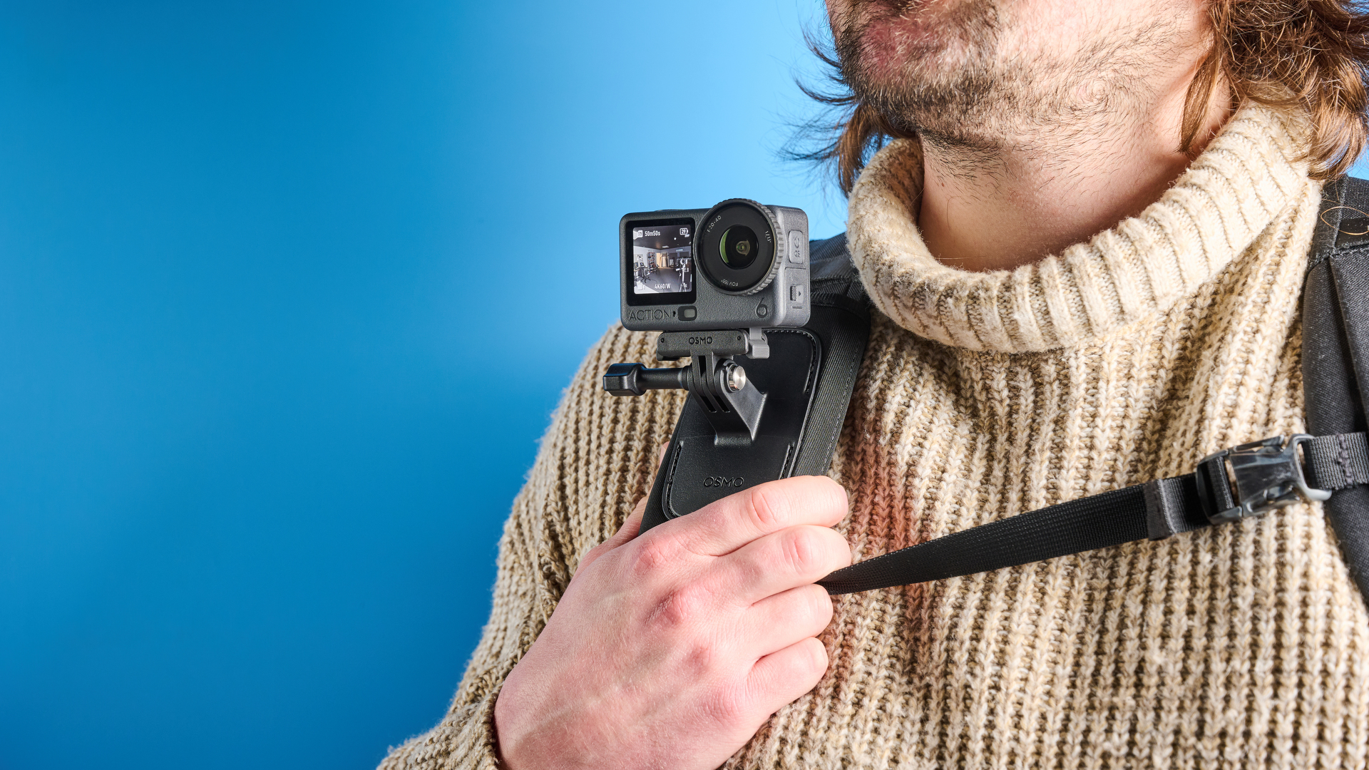 The DJI Osmo Action 6 mounted to a backpack strap