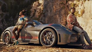 Clutch reveal trailer still - brother and sister leaning on a Porsche