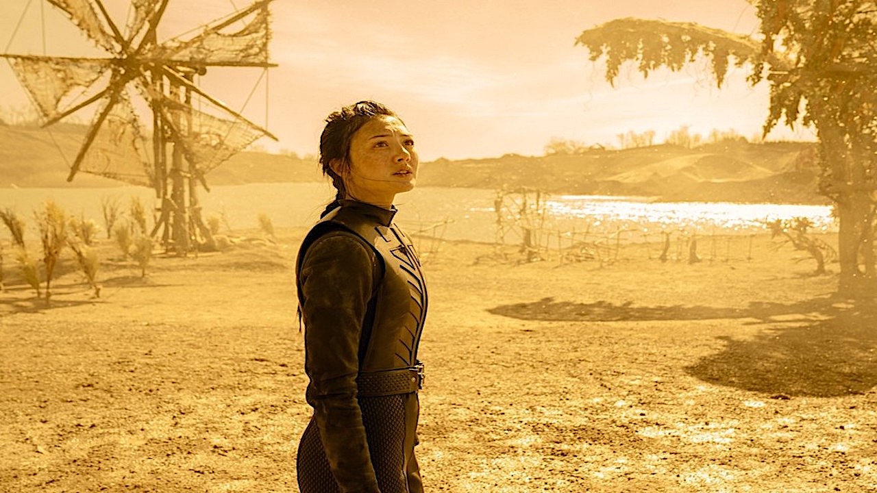 A young girl in black leather on a barren yellow-tinted planet