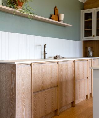 Budget kitchen with wood cabinets and green walls