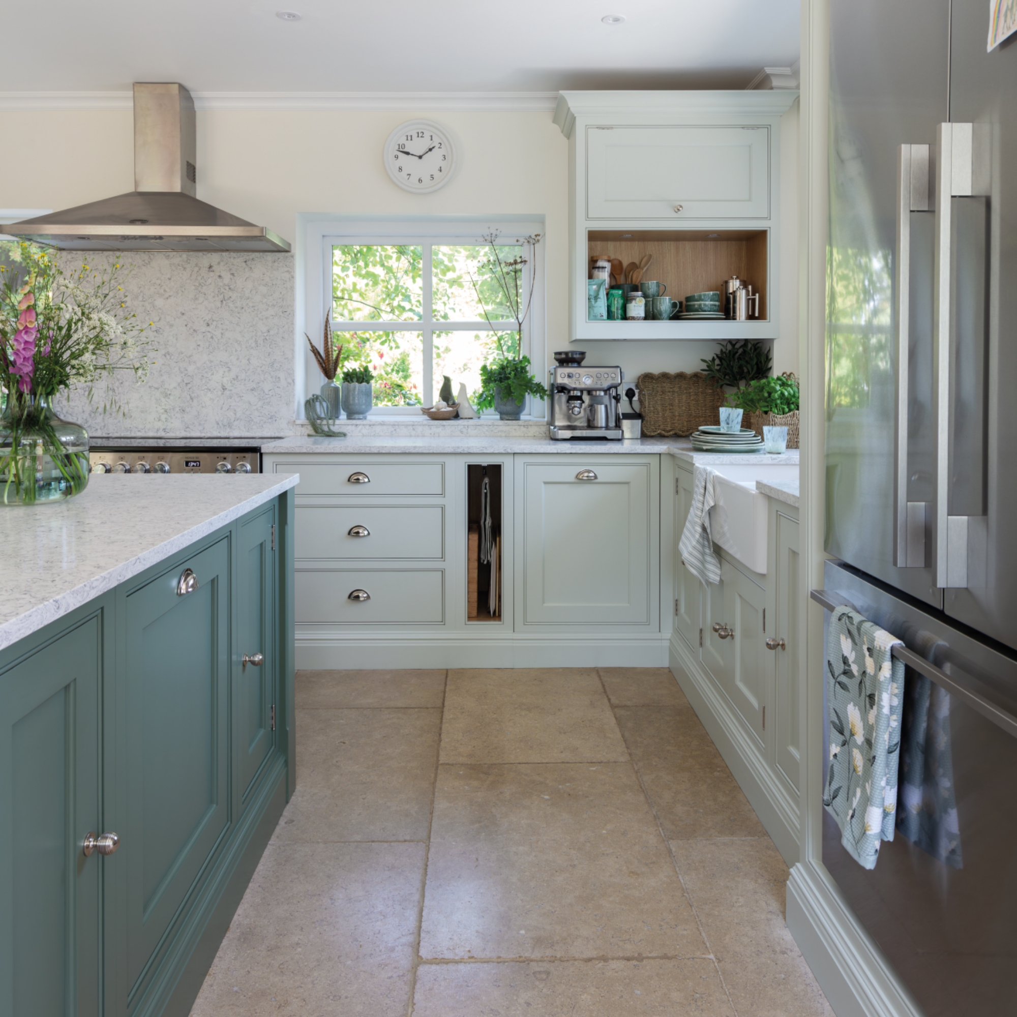 two tone colour kitchen with sage green island, pale green units, stone flooring