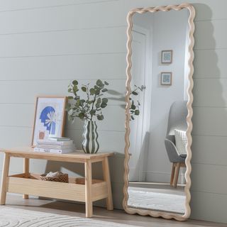 Wavy mirror in hallway with wooden bench