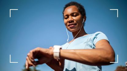 Woman checking smartwatch wearing headphones after exploring the benefits of running for women