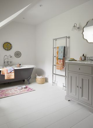 grey bathroom with laminate flooring, freestanding bath and vanity unit