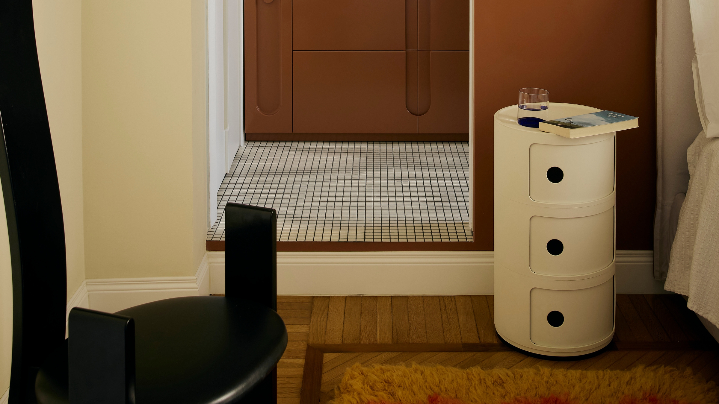 a white kartell componibili in a small bedroom