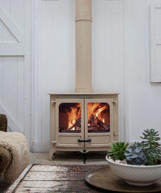 A traditional log burner in cream in a contemporary cottage living room