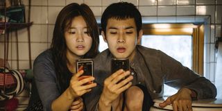 Kim Ki-jeong (Park So-dam) and Kim Ki-woo (Choi Woo-shik) sit in their bathroom and try to get cell