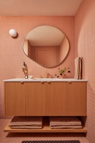 a bathroom with dark pink tiles on every wall