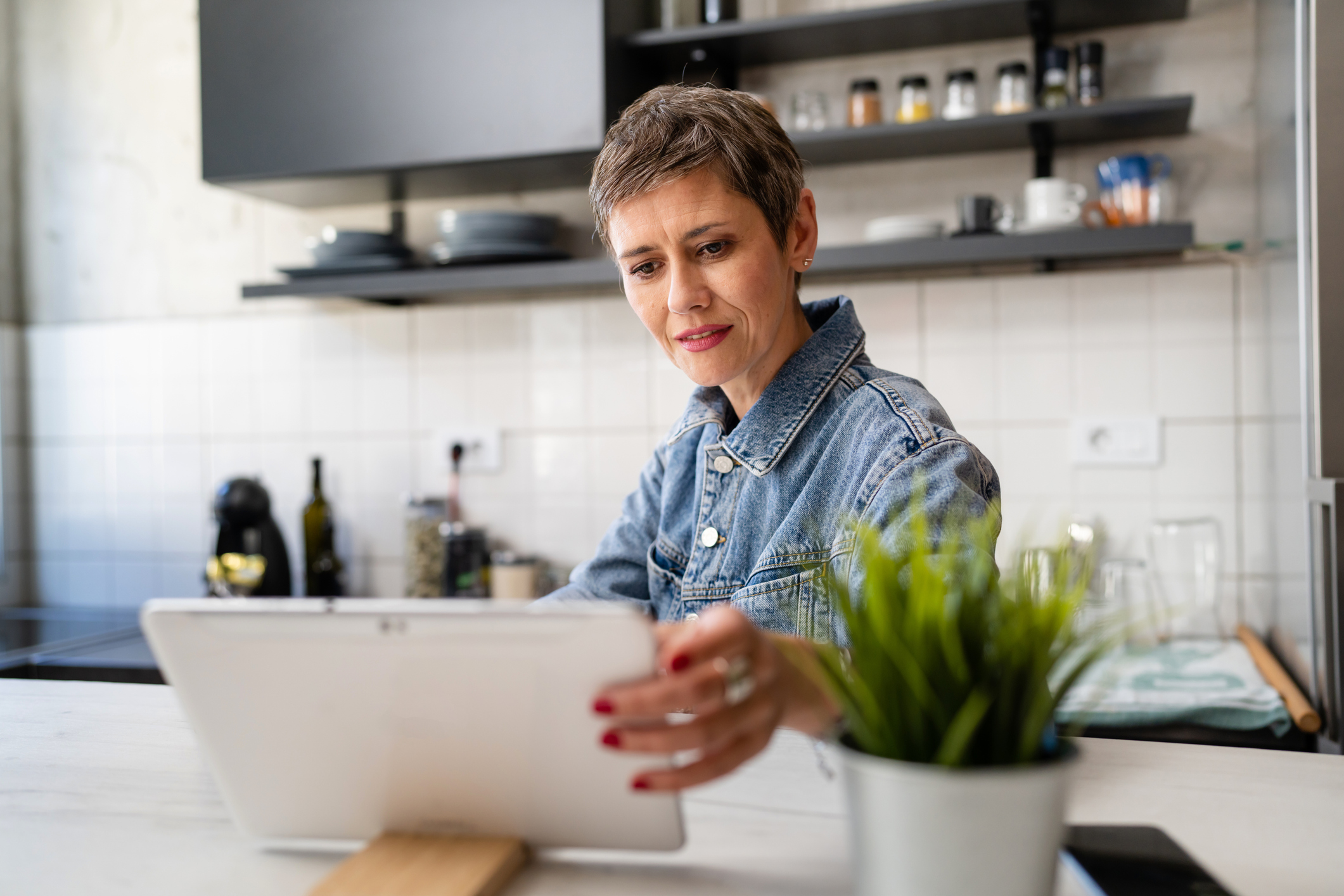 A woman in her kitchen using a tablet