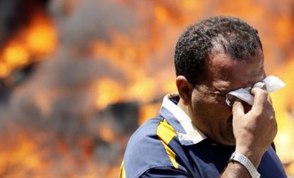 An Egyptian protester wipes his eyes after police fired tear gas at hundreds of young Egyptians demanding faster trials for members of Hosni Mubarak's regime.