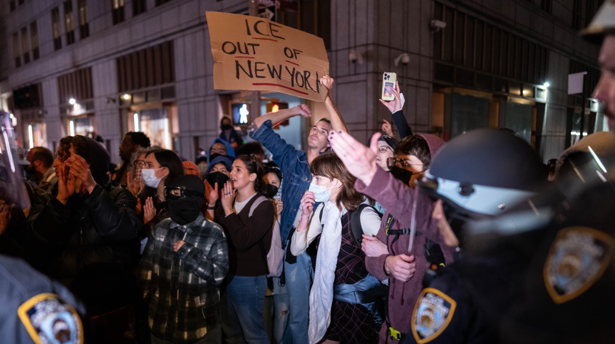 NEW YORK, NEW YORK - OCTOBER 21: People protest against an earlier raid by federal agents outside of 26 Federal Plaza on October 21, 2025 in New York City. 