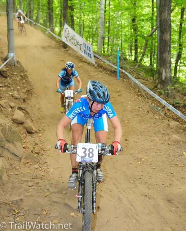 Kseniya Kirillova (Russian Federation) leads a group of riders down a dirt road.