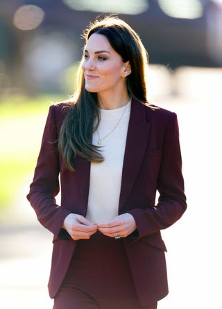 Kate Middleton wearing a plum suit.
