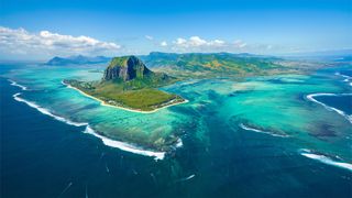 Aerial view of Mauritius island panorama and famous Le Morne Brabant mountain, beautiful blue lagoon and underwater waterfall.