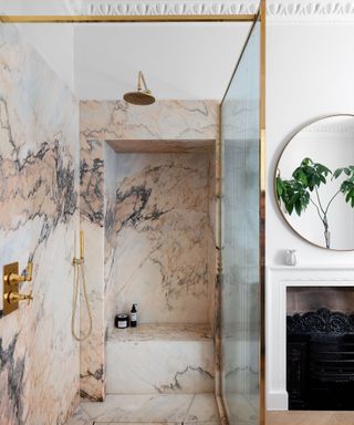 white bathroom with pink marble shower with gold enclosure
