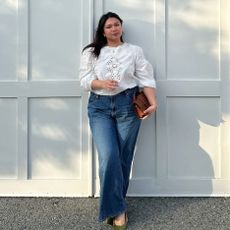 Marina wears pretty white lace blouse with wide blue jeans, green shoes and a brown leather handbag