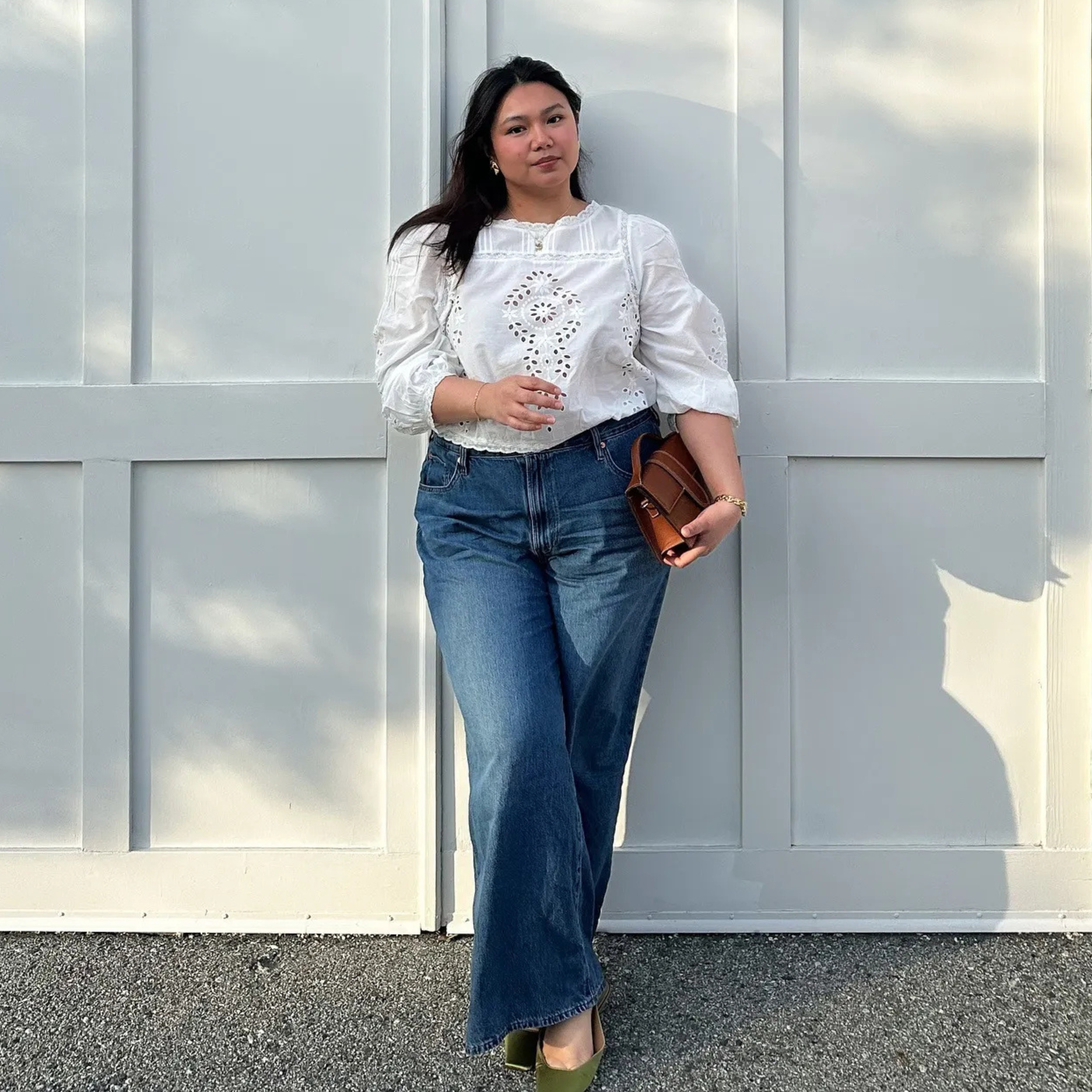 Marina wears pretty white lace blouse with wide blue jeans, green shoes and a brown leather handbag