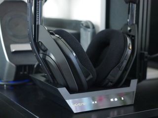 An Astro A50 headset sits in the charging dock.