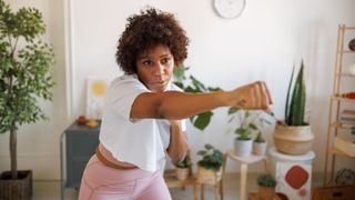 Woman shadow boxing at home, representing one of the many exercise snacks to do at home