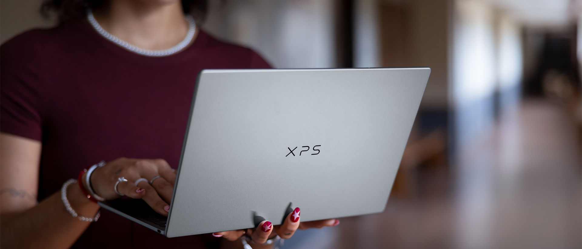 A woman holding a Dell XPS laptop