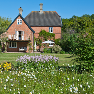 red stone house with a beautiful garden