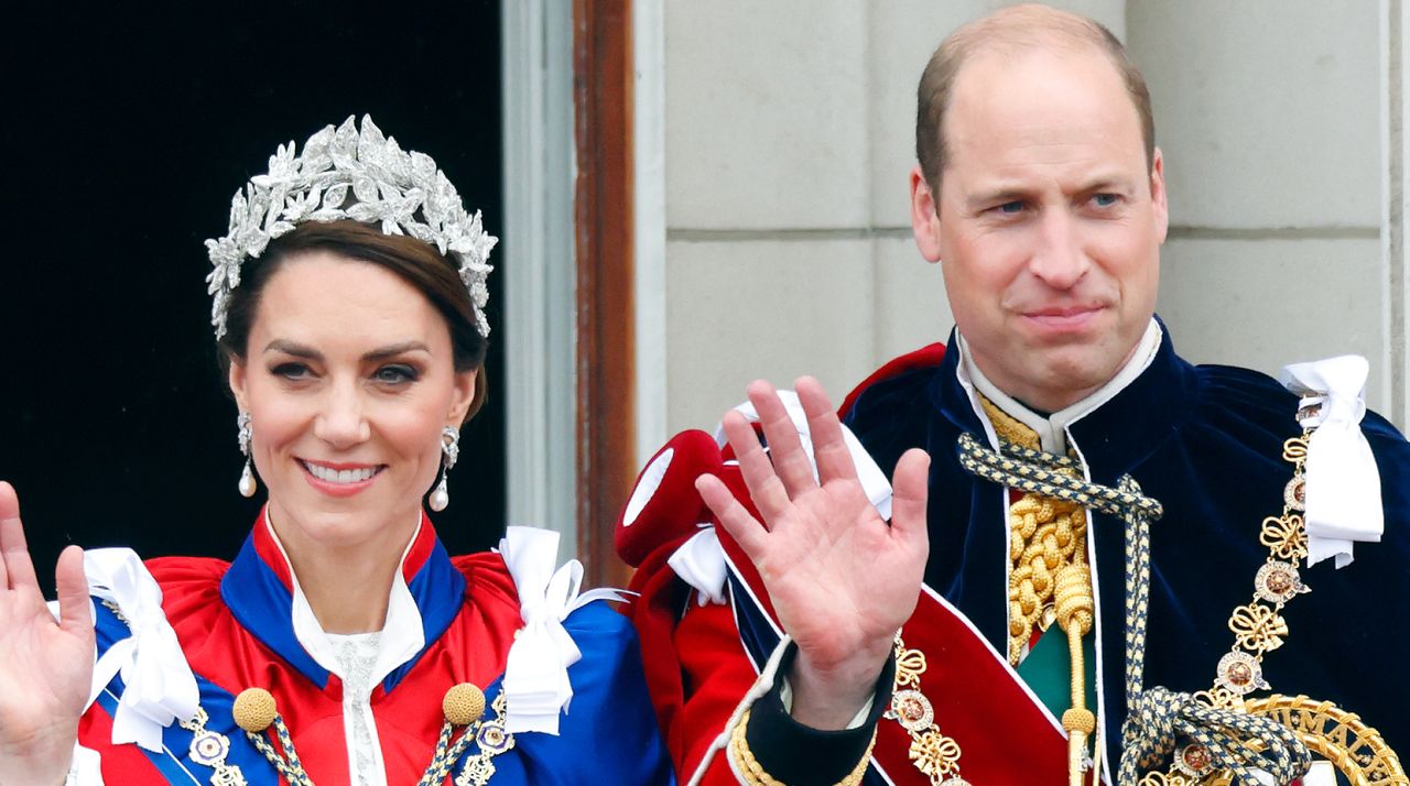 Kate Middleton and Prince William wave while wearing ceremonial robes on the Buckingham Palace balcony