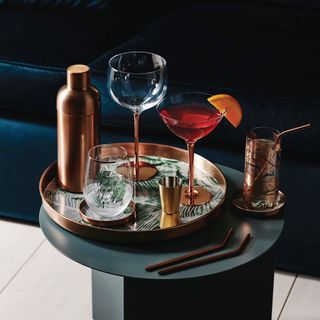 brushed metallic barware with cocktail glass and copper tray