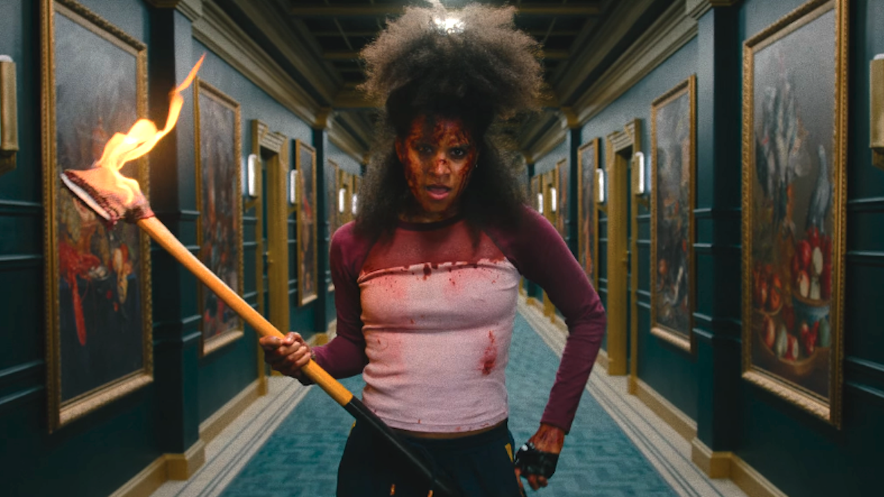 a bloodsoaked Zazie Beetz with a a flaming axe in They Will Kill You