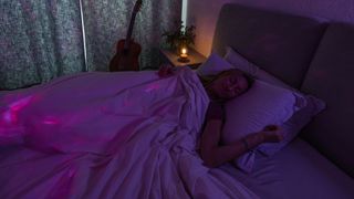 Woman sleeping with lights surrounding her which she can see when performing the 5-4-3-2-1 method