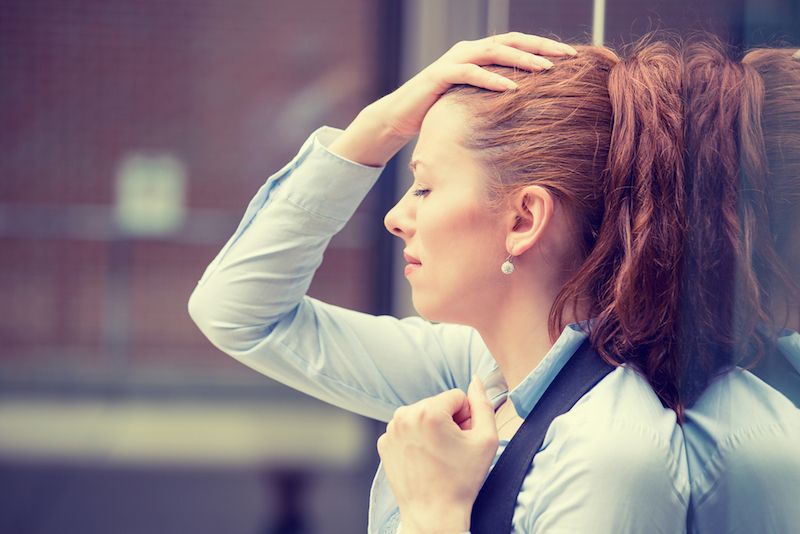 A woman looks overwhelmed with stress.