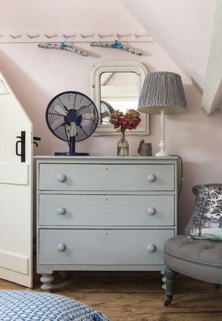 Grey chest of draws with three draws and 6 round handles