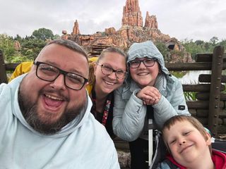 family of four smiling at Disneyland Paris