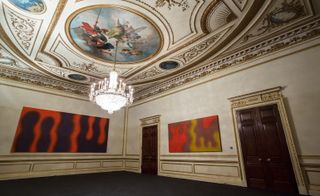 Wojciech Fangor painting's in a gallery with art painted on the roof and a large chandelier.