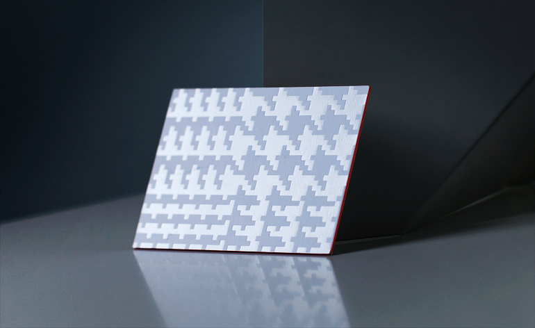 embossed with the duo-textured pattern in silk foil on mount board with bright orange edging