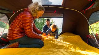 Woman setting up Yeti Lowlands Blanket inside tent