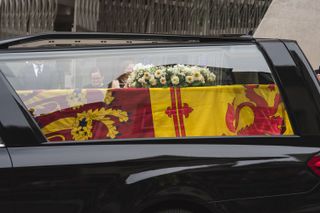 a close of Queen Elizabeth II's coffin in the procession car